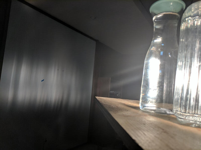 Shining light through two differently-shaped glass bottles of water to create this vertical ripple effect in a closeup.